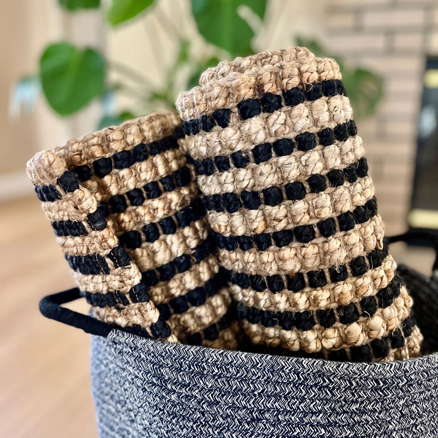 Handcrafted Caravan striped jute rugs in a small size, displayed in a basket.