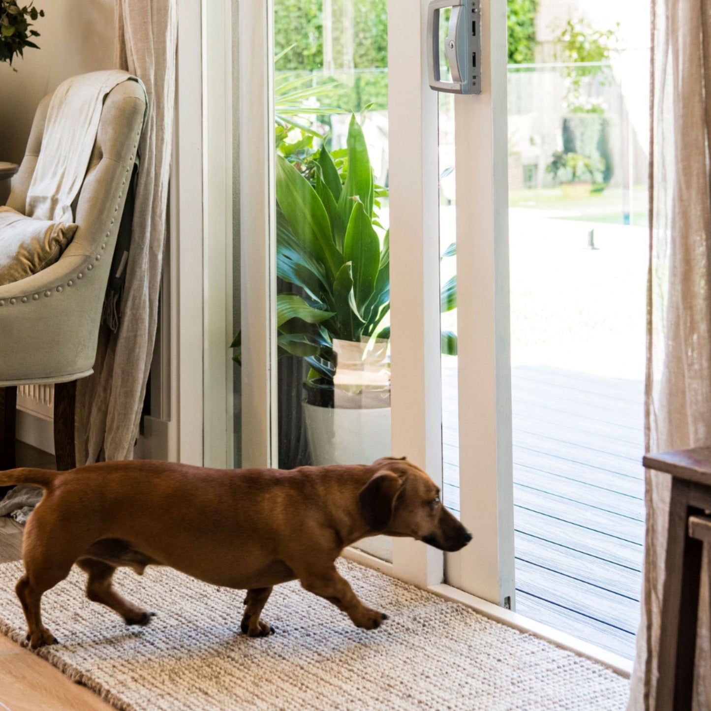 Carter handcrafted, grey and white heathered wool and jute bouclé small rug on a wooden floor entryway.