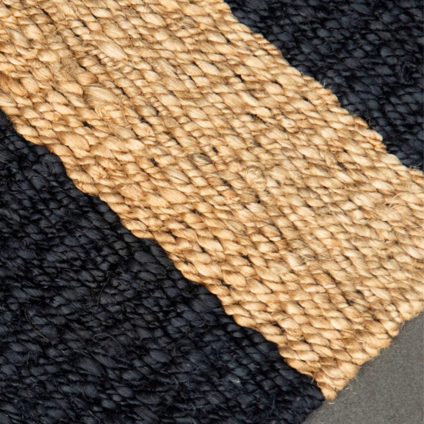 Close-up of the flat weave texture and graphite stripe on the Irving jute small rug.