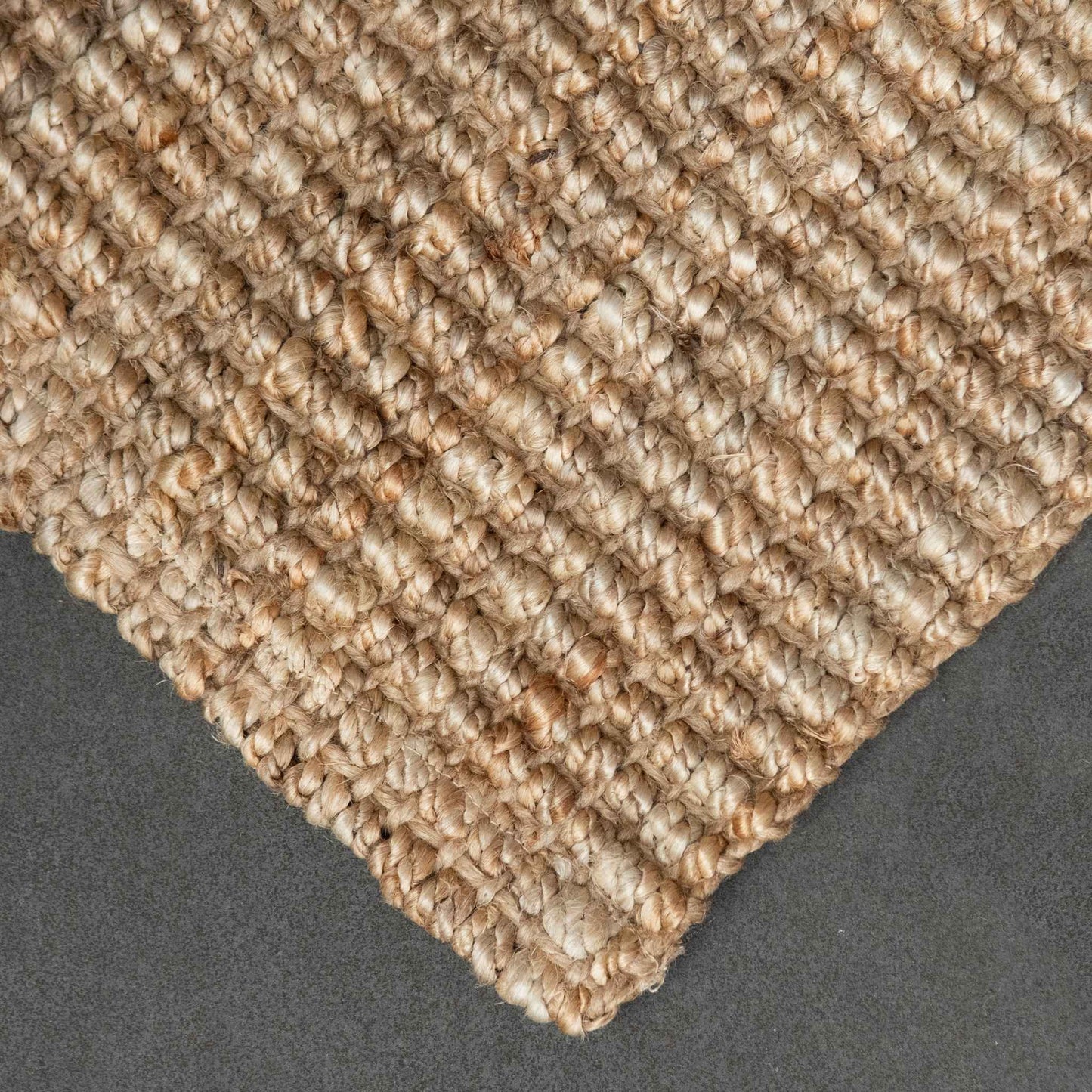 Close-up of Handcrafted natural bouclé weave jute texture with slate background.