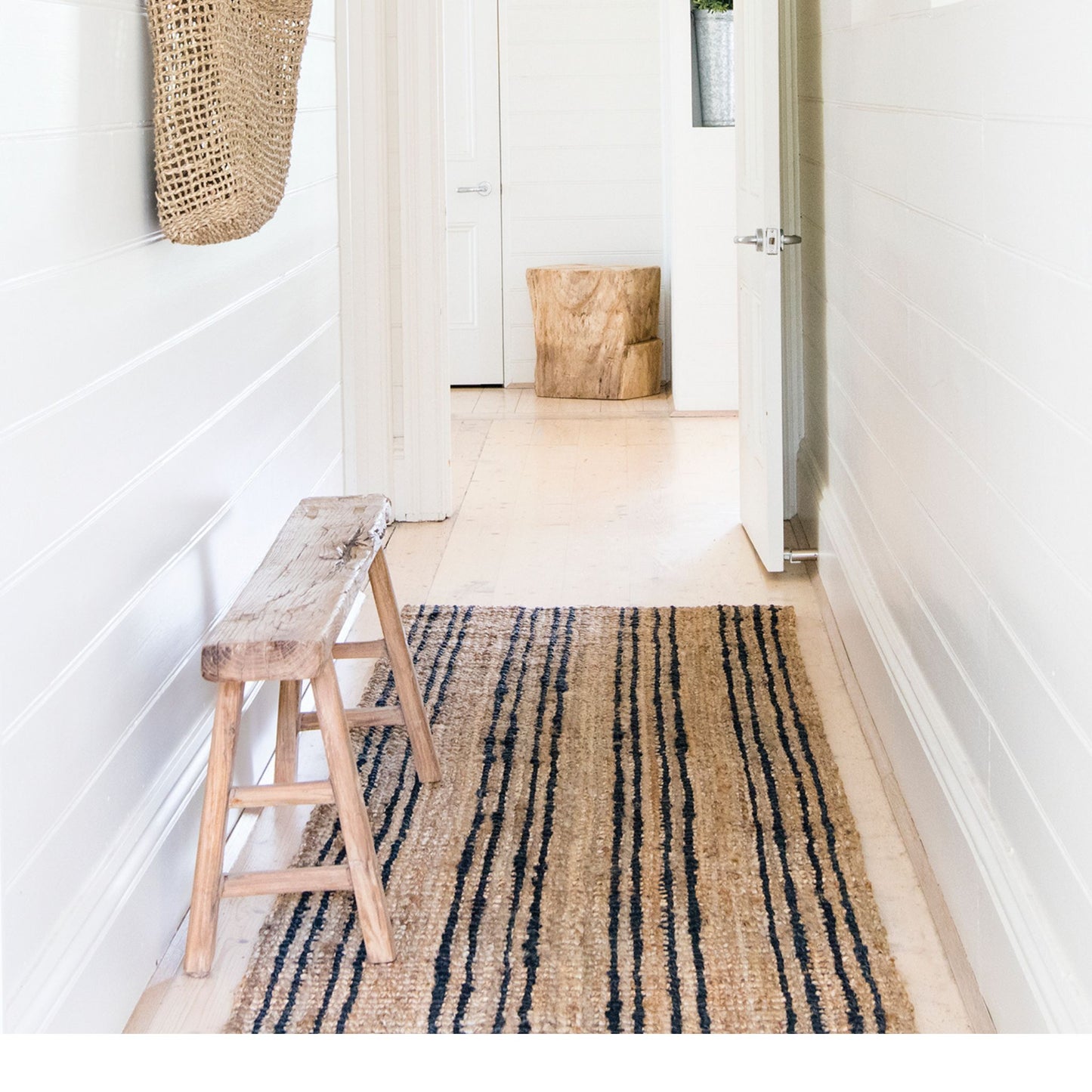 Smith natural bouclé jute runner rug with graphite stripes on light timber floor entryway in a beach style cottage.