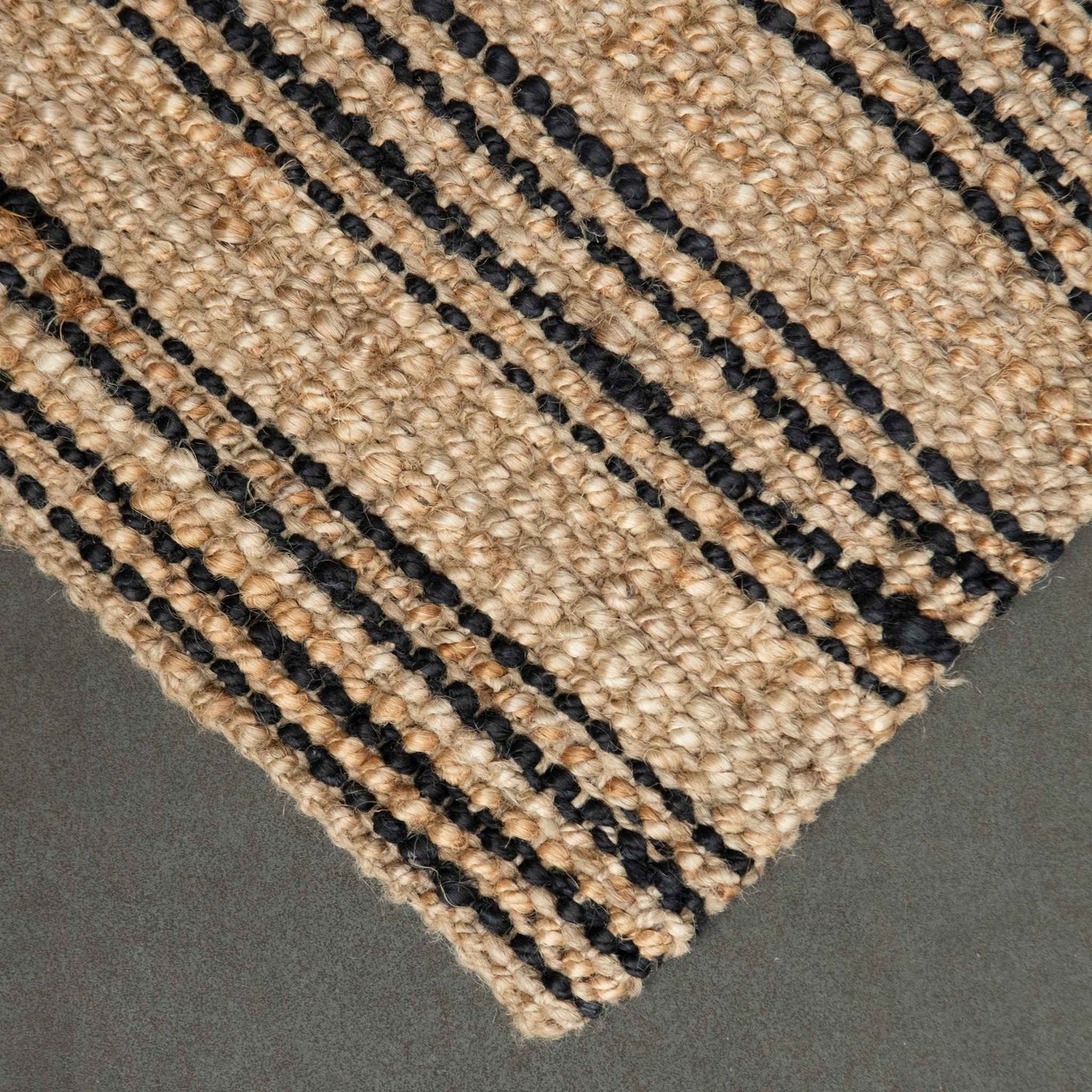 Close-up of the woven, chunky bouclé texture and graphite stripes on the Smith style jute rug.