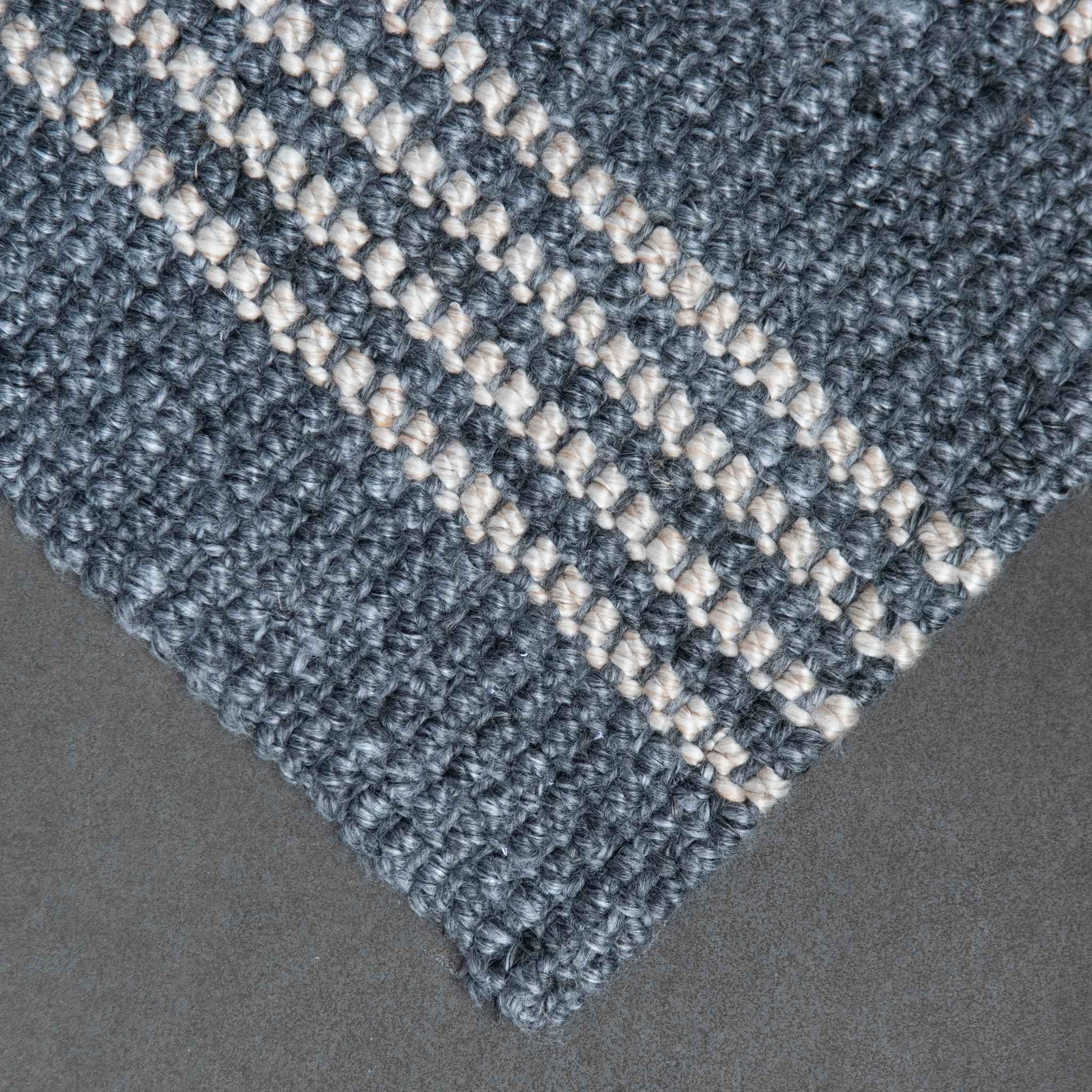Close-up of Macintosh flatweave slate grey rug with natural stripes, made from 100% recycled PET with slate background.