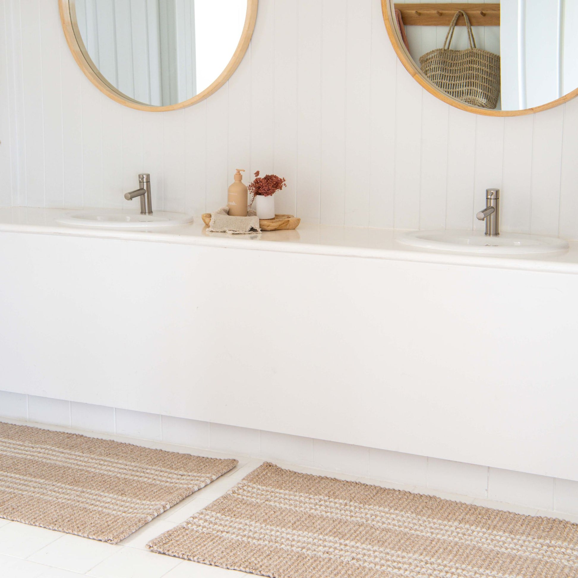 Franklin flatweave rug, with natural and white stripes, made from 100% recycled PET on tile in white, modern bathroon.