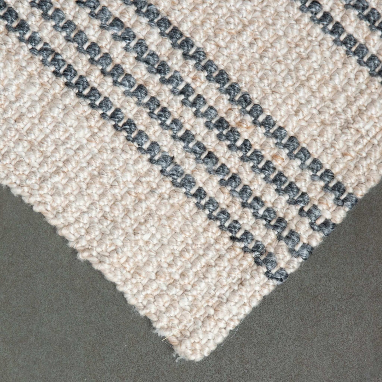 Close-up of Macintosh flatweave rug, with natural and slate grey stripes made from 100% recycled PET with slate background.