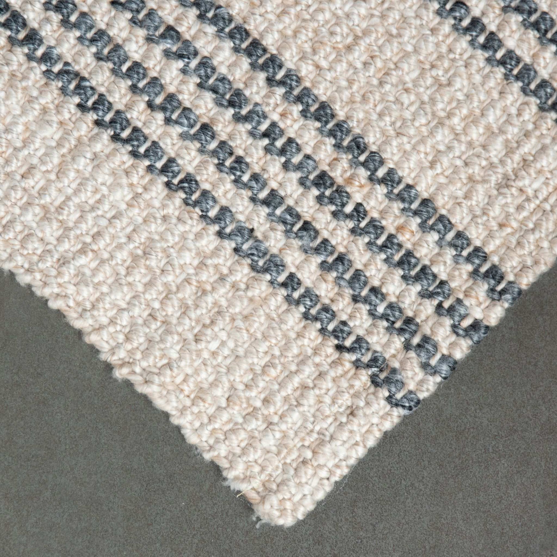 Close-up of Macintosh flatweave rug, with natural and slate grey stripes made from 100% recycled PET with slate background.