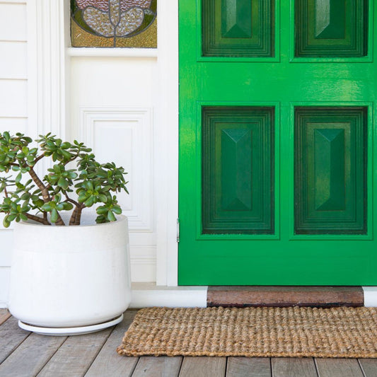 Handcrafted natural bouclé jute small rug on a undercover porch. 
