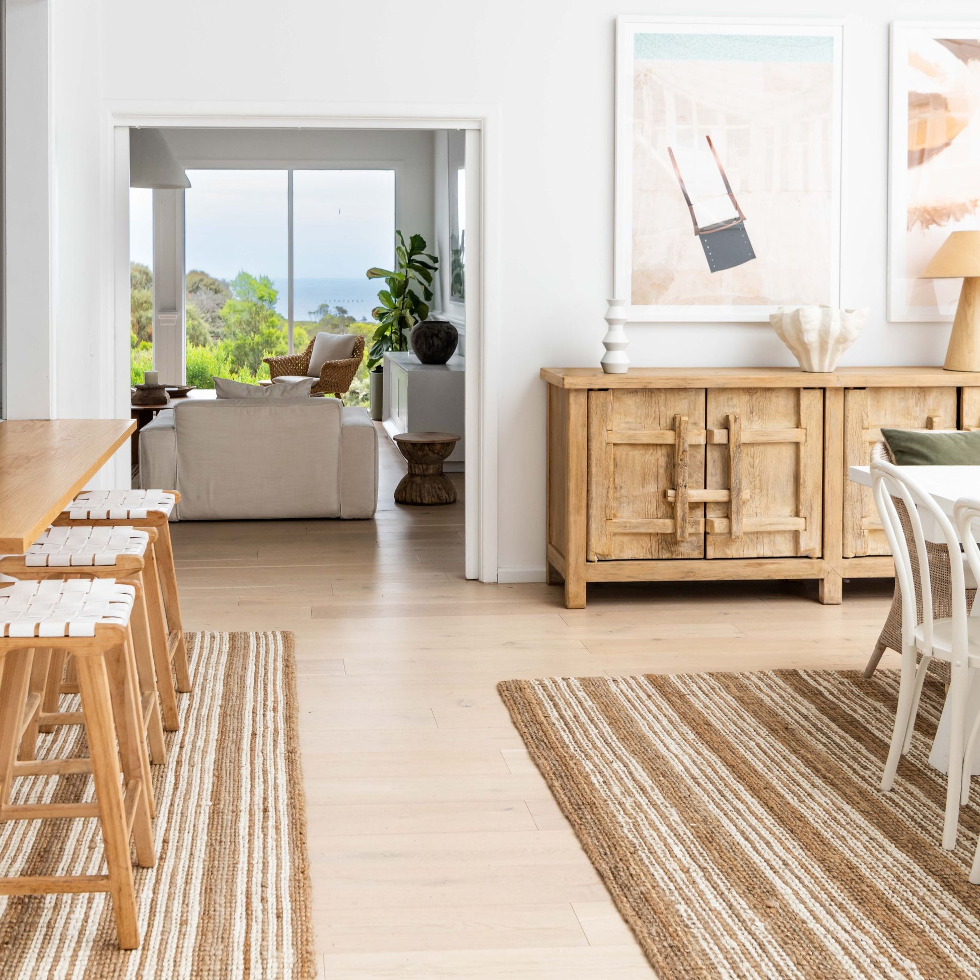 Osbourne natural chunky jute bouclé area rug and runner rug with white stripes, in an open plan modern coastal home with a view.