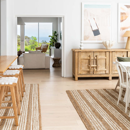 Osbourne natural chunky jute bouclé area rug and runner rug with white stripes, in an open plan modern coastal home with a view.