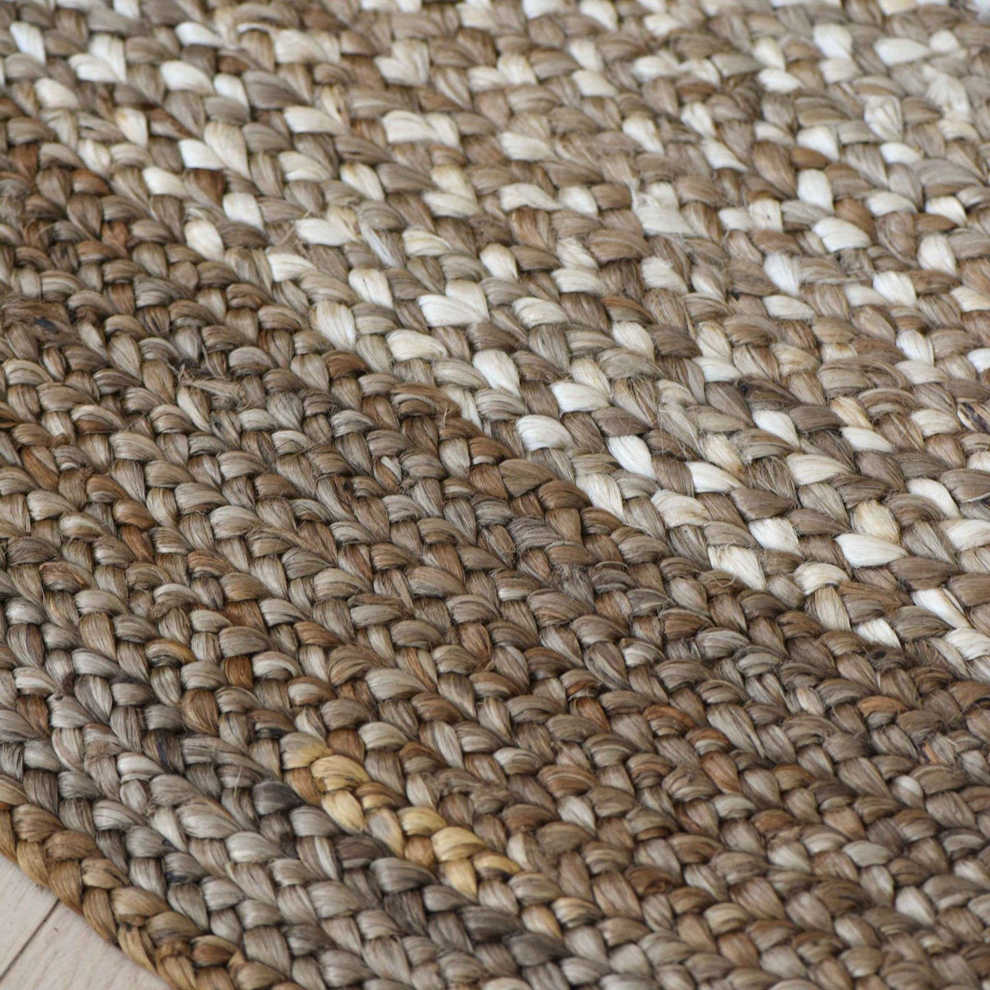 Close-up of Westmore hand-braided two toned natural, jute round rug with a border.