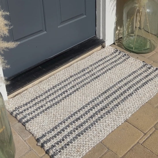 Close-up video of Macintosh flatweave slate grey rug with natural stripes, made from 100% recycled PET.