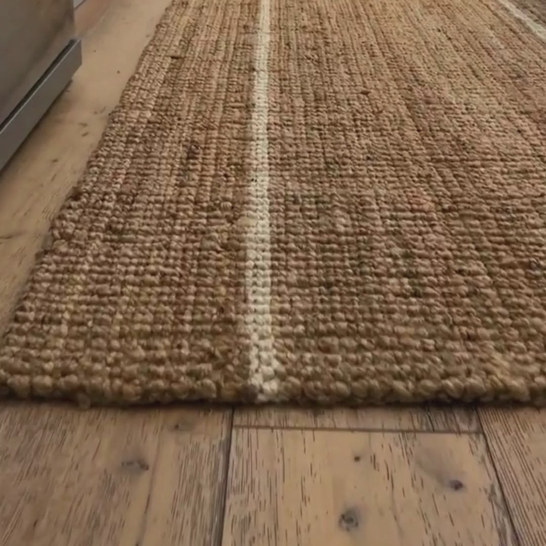 Close-up video of the woven bouclé  texture and white stripes on the Robinson jute runner rug.