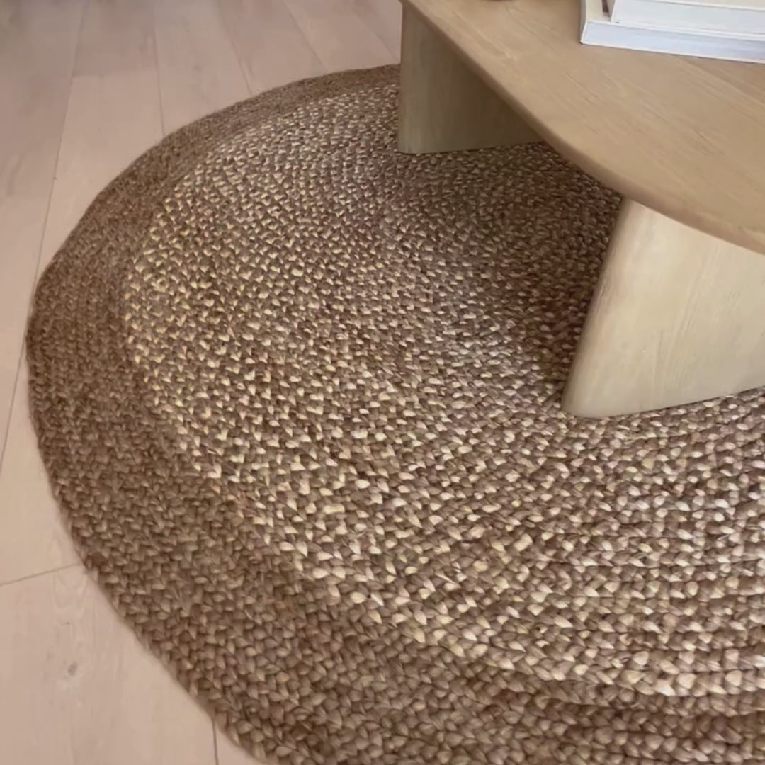 Close-up video of Westmore hand-braided two toned natural, jute round rug in a living room.