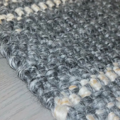 Close-up of Cornell video flatweave rug, with slate grey and natural stripes made from 100% recycled PET. 