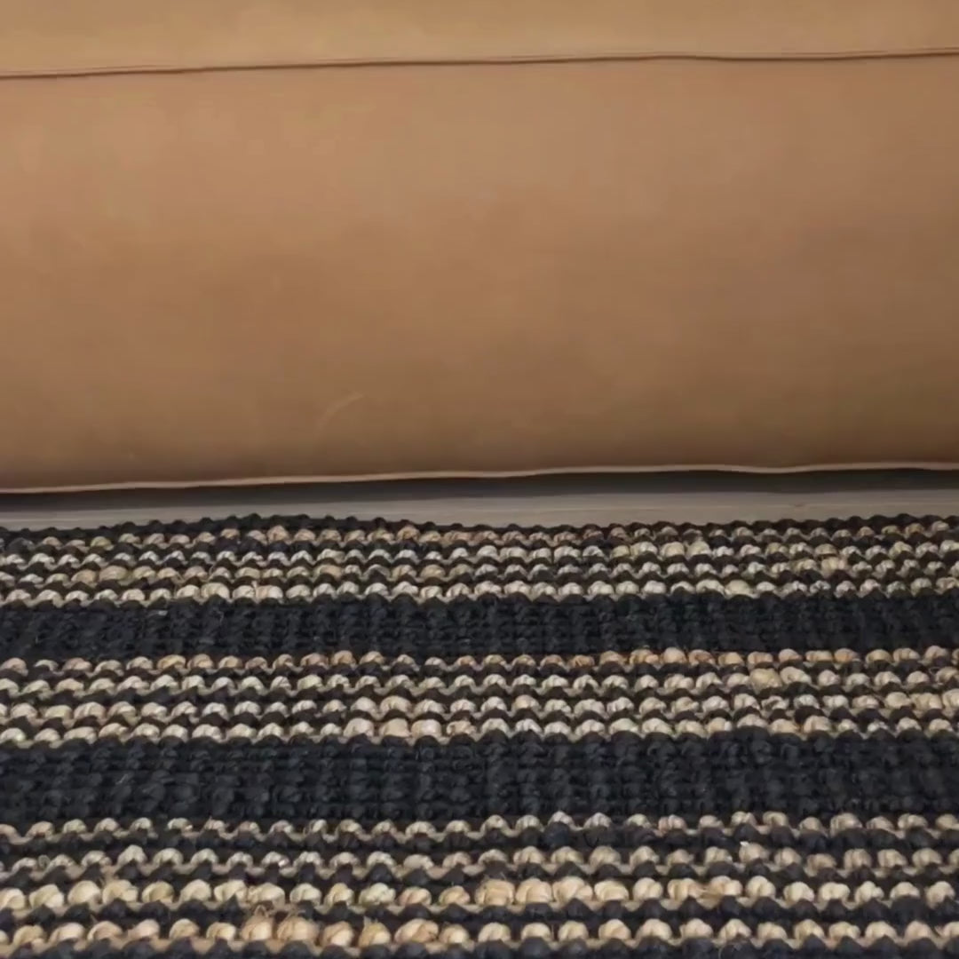 Close-up video of the Jones rug with Graphite woven bouclé  texture and natural stripes.