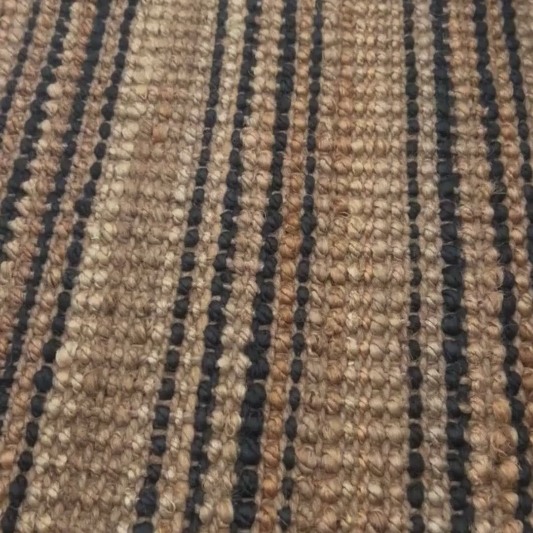 Close-up video of the woven, chunky bouclé texture and graphite stripes on the Smith style jute rug.