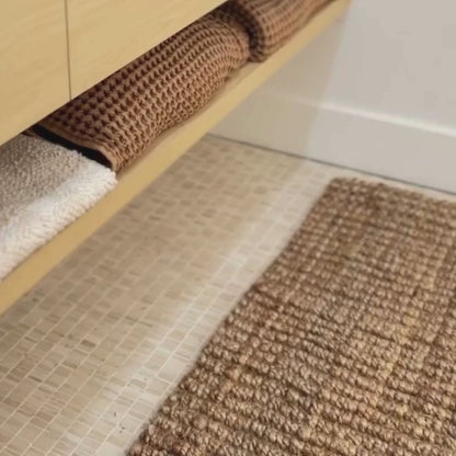Close-up video of the woven bouclé  chunky texture of the Natural rug in a bathroom.