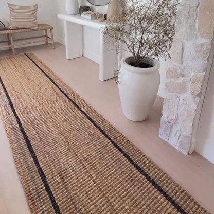 Close-up of the Bailey runner rug with natural woven bouclé texture and graphite stripes at an front door entrance.